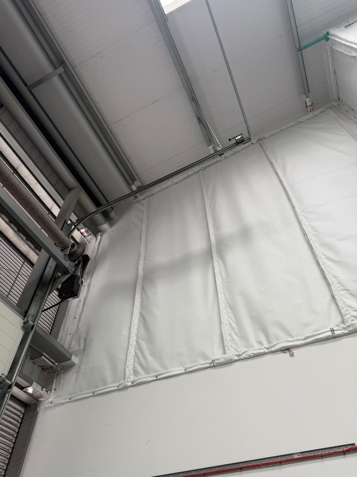 Barrier panels running up to the roof beside the roller shutter